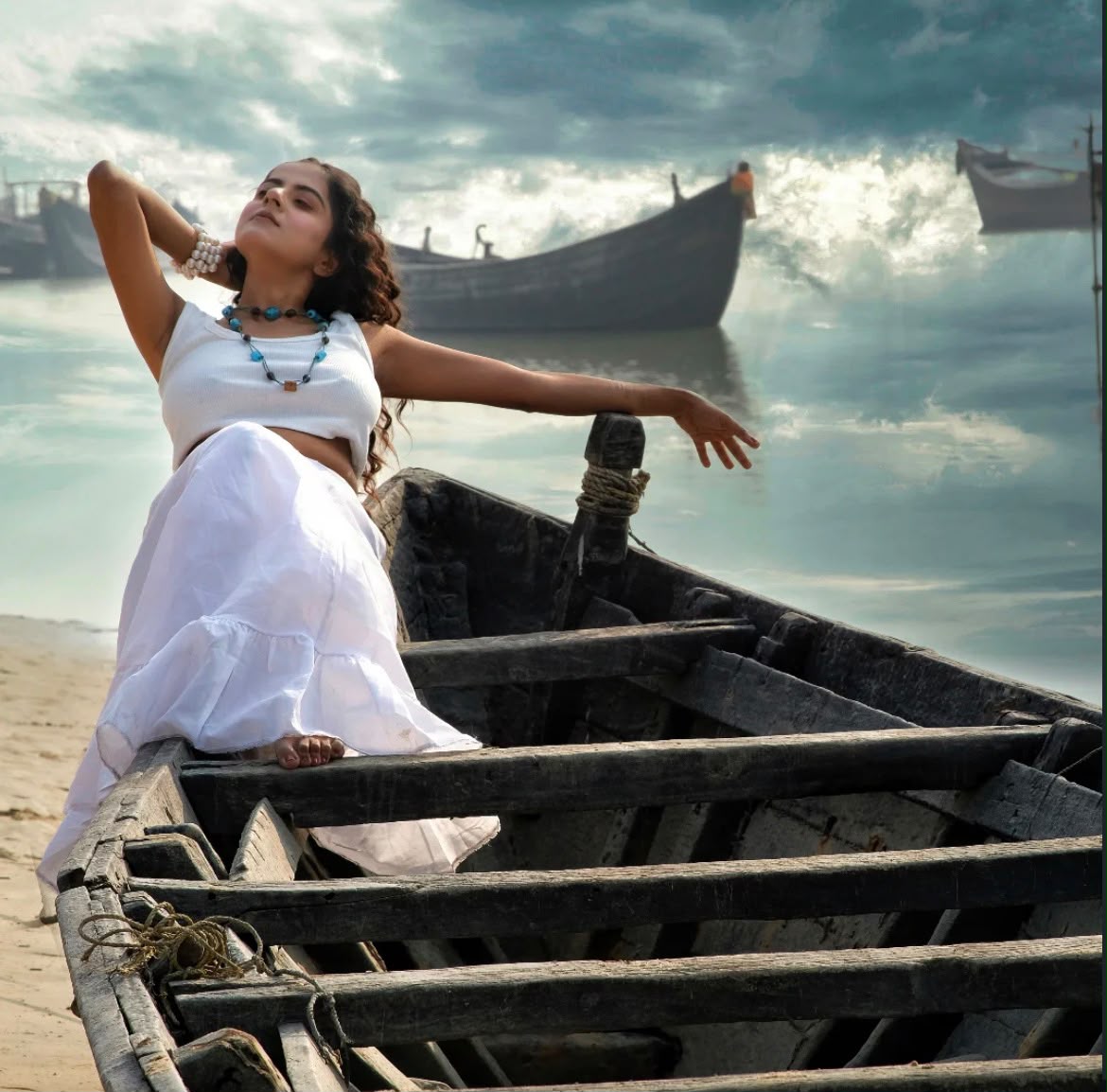 Woman in white reclining on a fishing boat under a dramatic sky