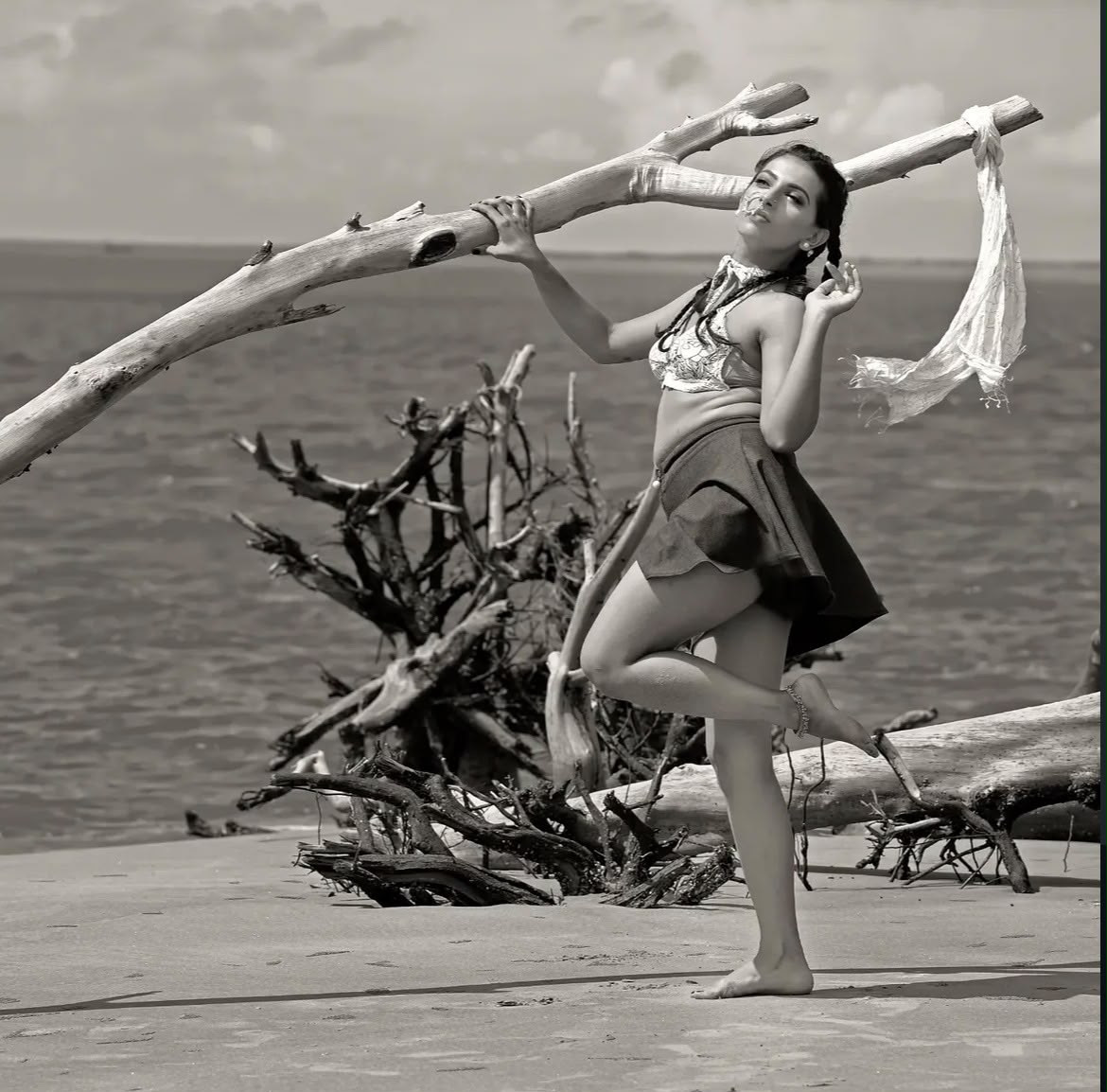 Black and white fashion portrait on a beach with driftwood