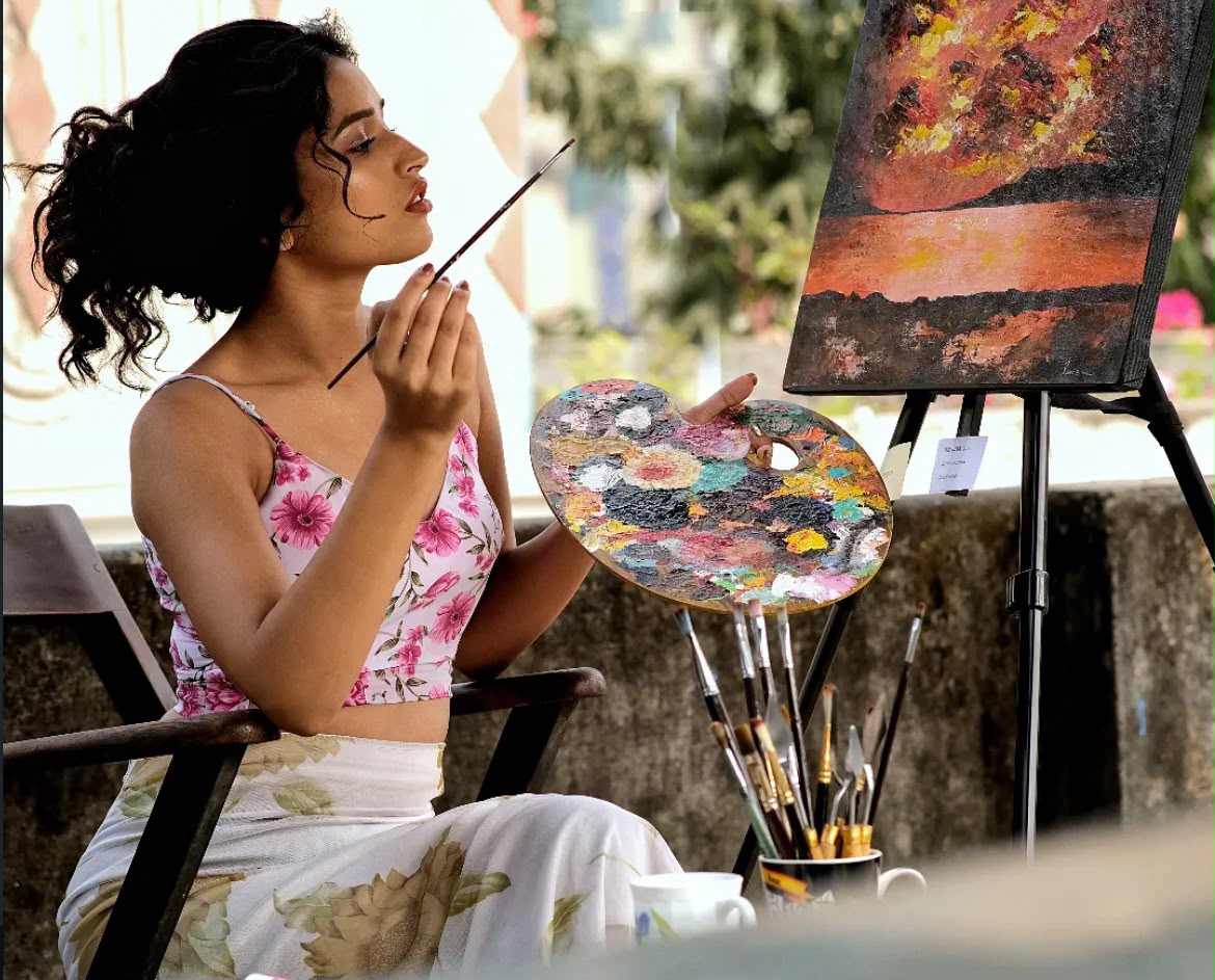 Woman painting at an easel in soft natural light